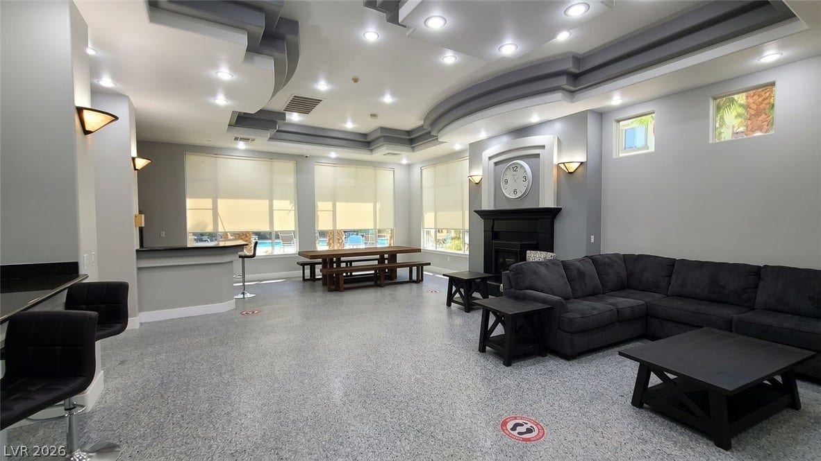 7173 S Durango Drive, #212, Las Vegas, NV 89113 Inlaid architectural ceilings and polished flooring define this spacious multi-functional common room with fireplace.