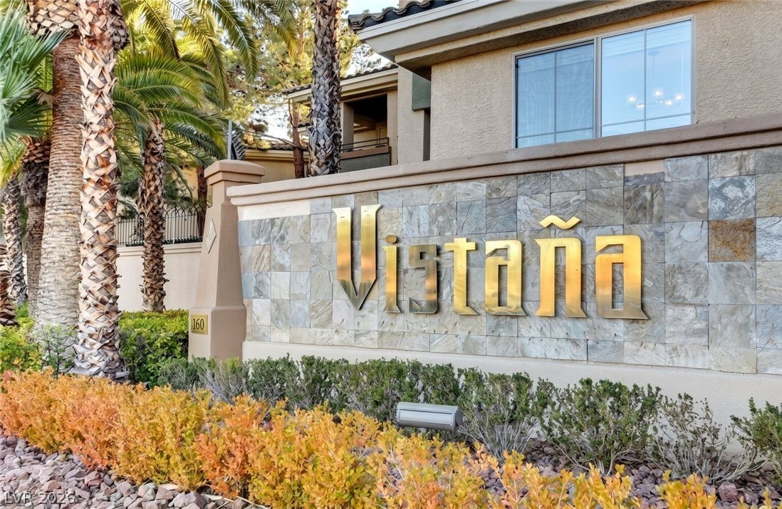 7173 S Durango Drive, #212, Las Vegas, NV 89113 Mature palms frame the entrance monument displaying a welcoming, clean stucco and stone architectural design.