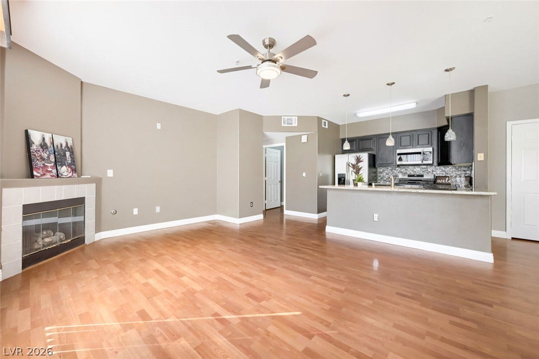 7173 S Durango Drive, #212, Las Vegas, NV 89113 Gleaming hardwood floors and a tile fireplace anchor this open-concept main living area.