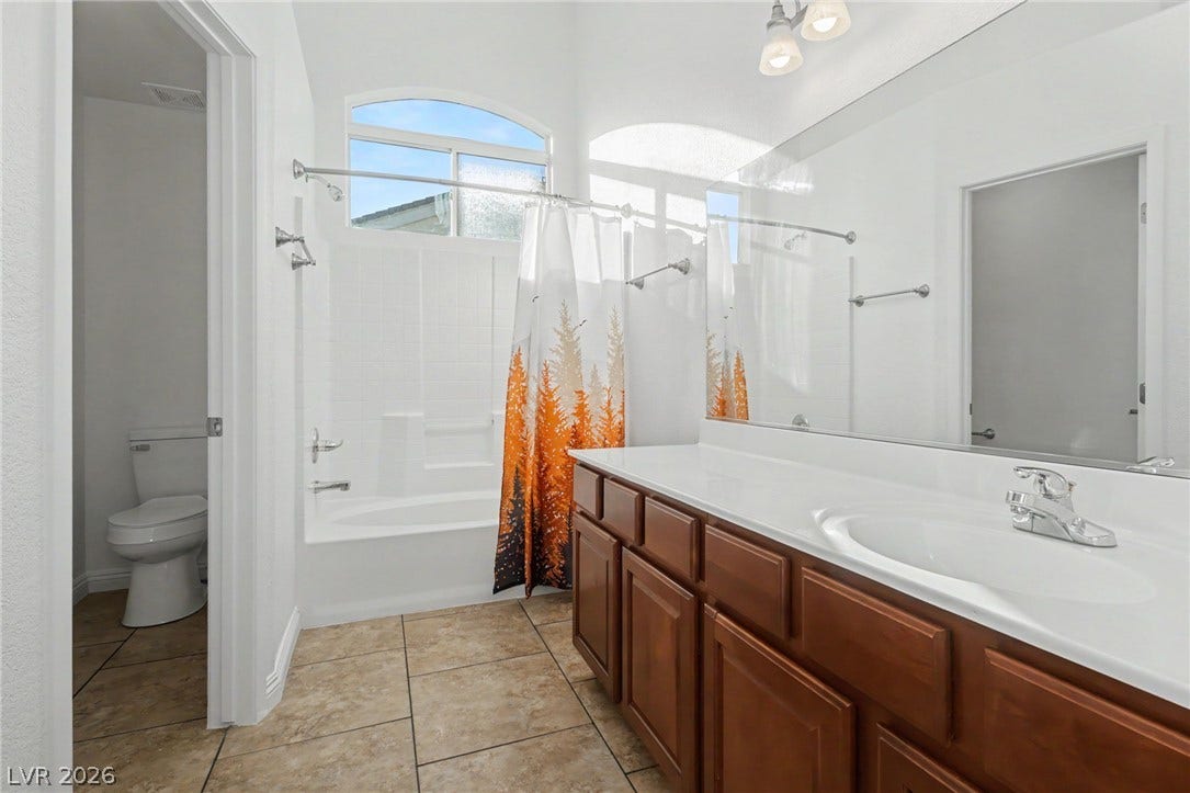 1555 Ward Frontier Lane, Henderson, NV 89002 High ceilings and neutral tile floors elevate this well-appointed bathroom with built-in tub.