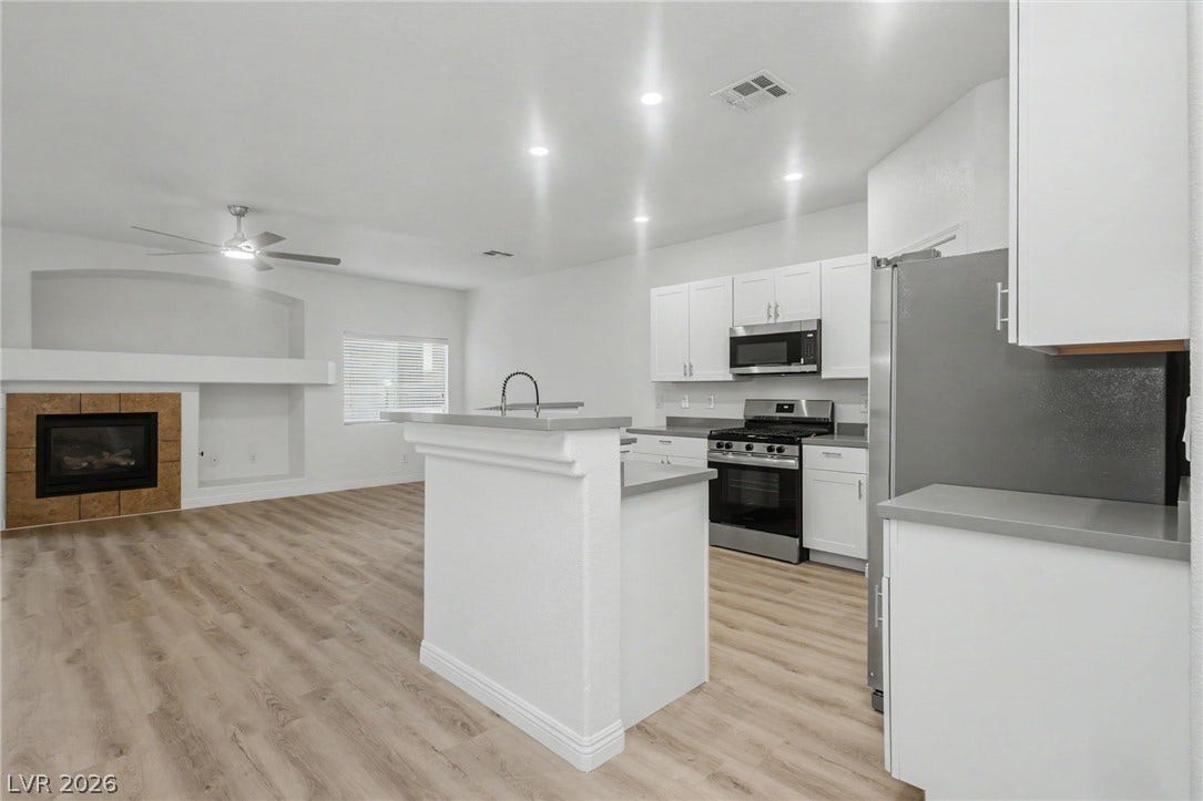 1555 Ward Frontier Lane, Henderson, NV 89002 An open floor plan connects the kitchen to a spacious living room with fireplace.