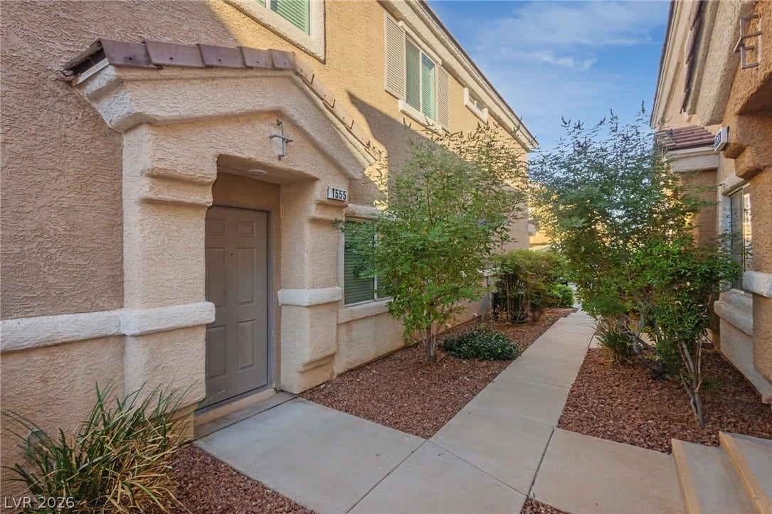 1555 Ward Frontier Lane, Henderson, NV 89002 A welcoming concrete pathway guides visitors past desert landscaping to the recessed front entry.