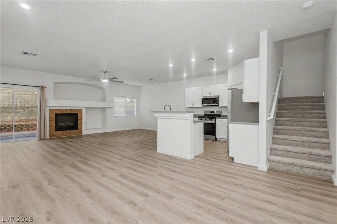 1555 Ward Frontier Lane, Henderson, NV 89002 Plank flooring and a gas fireplace anchor this versatile, open-concept living area.