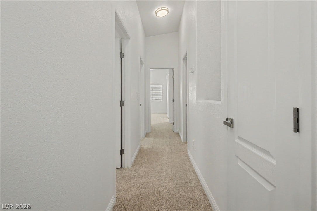 1555 Ward Frontier Lane, Henderson, NV 89002 Soft carpeting flows through this hallway connecting the home's private spaces.