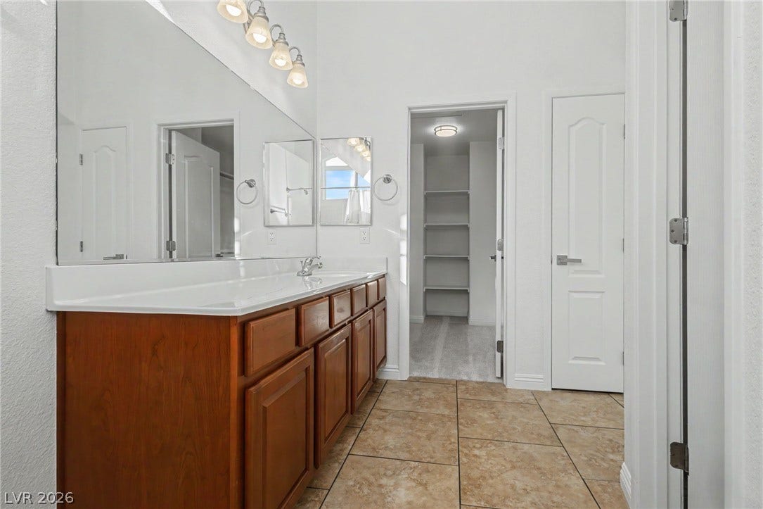 1555 Ward Frontier Lane, Henderson, NV 89002 A spacious vanity with ample storage leads directly into a large walk-in closet.