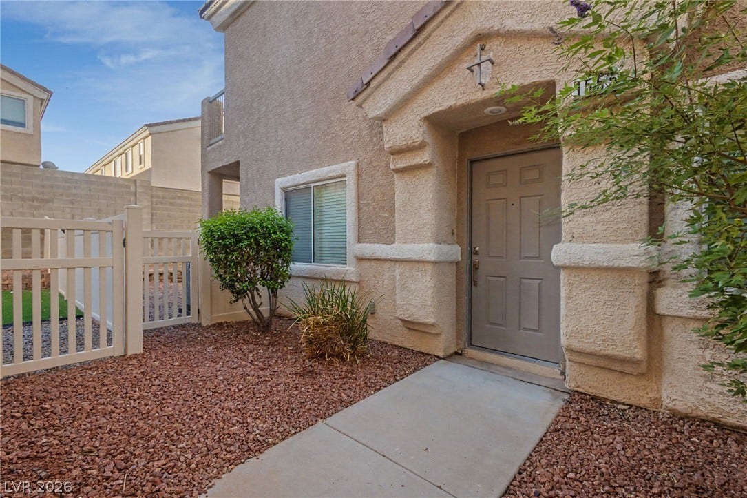 1555 Ward Frontier Lane, Henderson, NV 89002 An inviting concrete walkway leads directly to the covered private entrance of this stucco home.