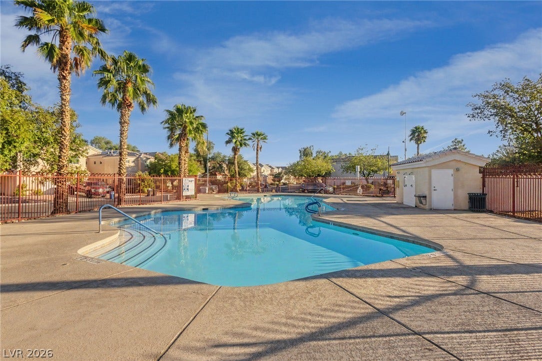 1555 Ward Frontier Lane, Henderson, NV 89002 Palm trees frame a sparkling community pool set within a spacious concrete deck.