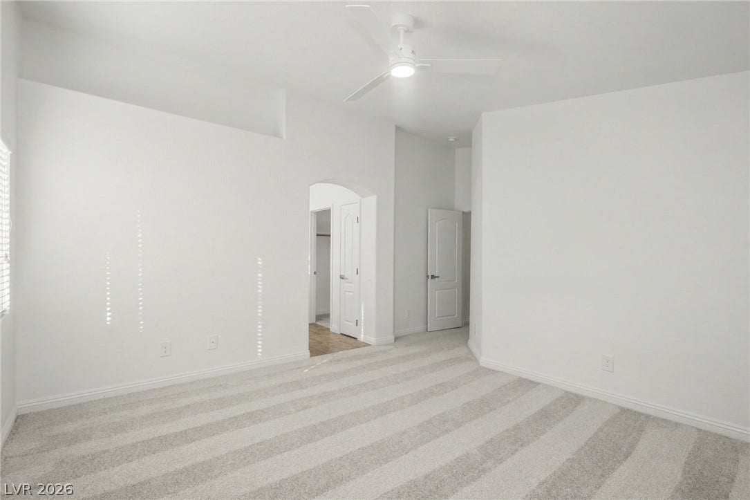 1555 Ward Frontier Lane, Henderson, NV 89002 Crisp white walls and patterned carpeting define this airy bedroom space.