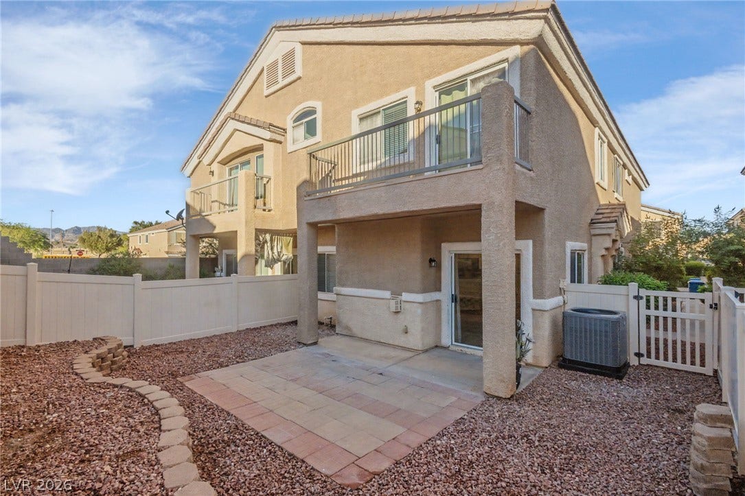 1555 Ward Frontier Lane, Henderson, NV 89002 An inviting paved patio sits beneath a private upper balcony overlooking the gravel yard.