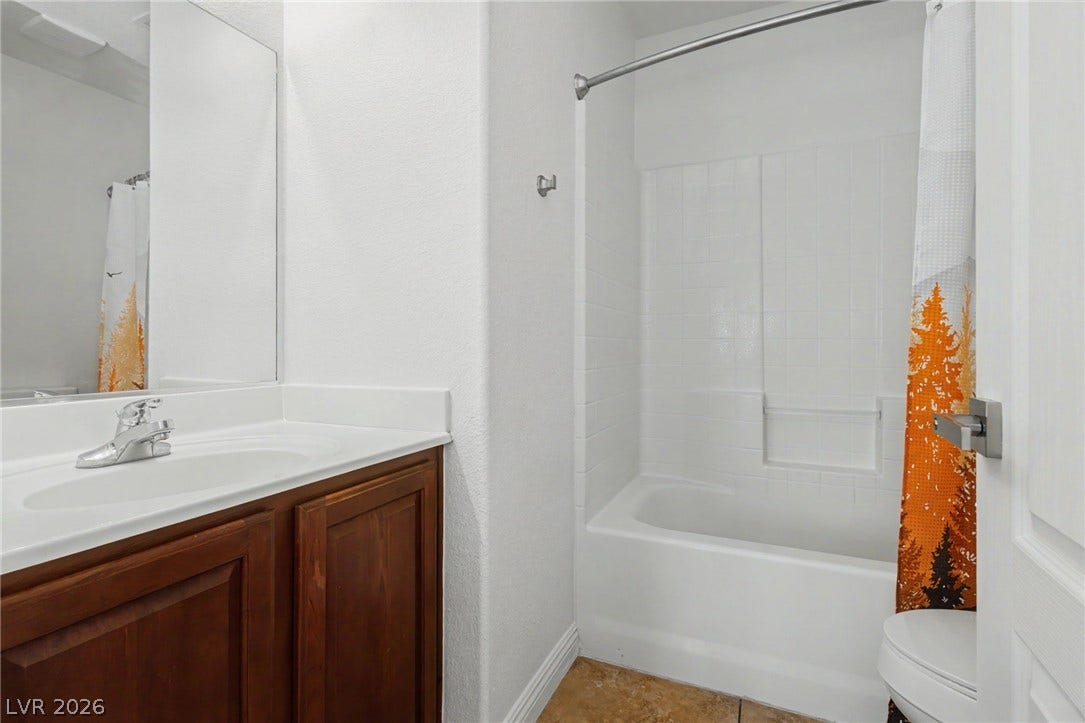 1555 Ward Frontier Lane, Henderson, NV 89002 A classic vanity stands opposite a tiled tub and shower combination.