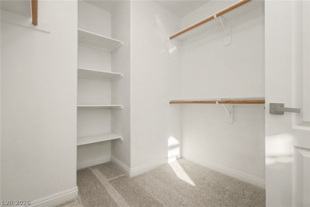 1555 Ward Frontier Lane, Henderson, NV 89002 Ample built-in shelving and hanging rods maximize storage space inside this carpeted closet.