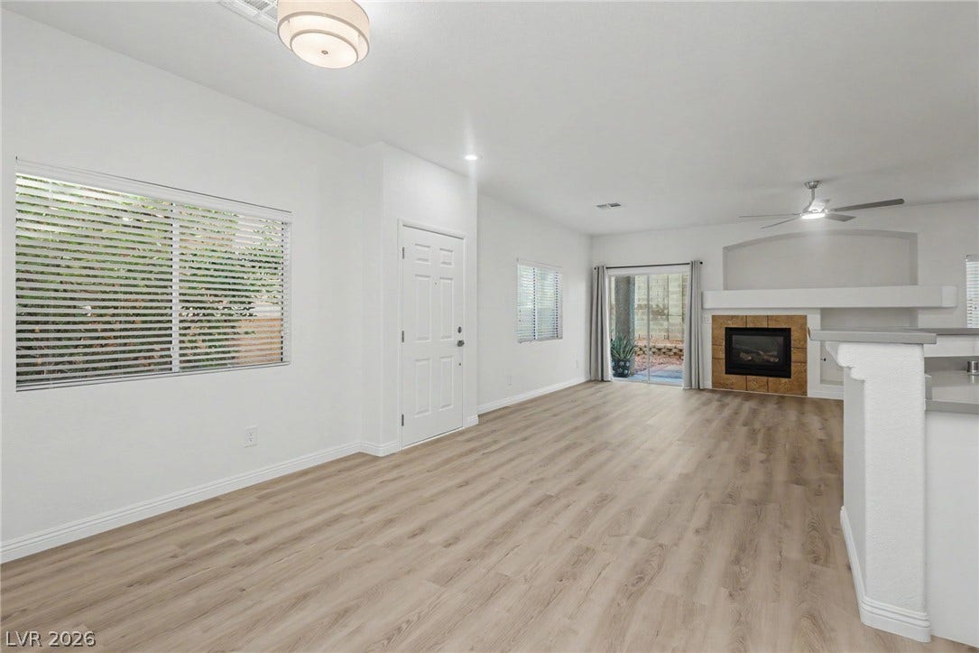 1555 Ward Frontier Lane, Henderson, NV 89002 Clean lines and warm wood-style flooring flow through this inviting living area featuring a fireplace.