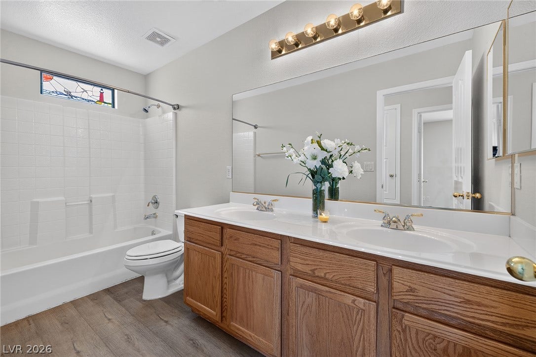 Upstairs Hall Bathroom features a tub/shower, double sinks, ample storage and a decorative window above the tub elevate this functional bathroom space.