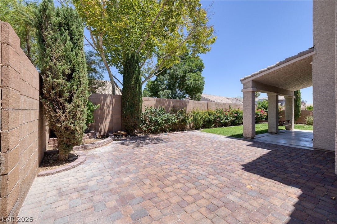 An expansive, paver-lined backyard patio provides ample room for outdoor entertaining.