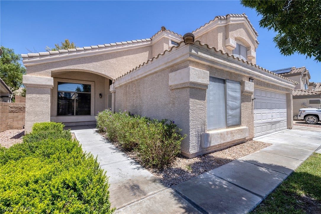 A two-story stucco home with an attached 2-car garage.