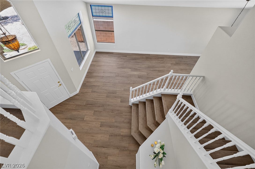 A grand entrance with high ceilings and rich wood flooring awaits.