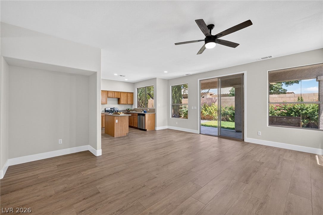 An open floorplan seamlessly connects the kitchen and living areas, offering views of the private backyard.