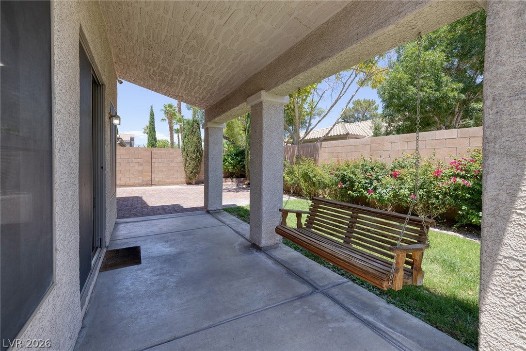 Relax on the covered patio swing overlooking the verdant backyard.