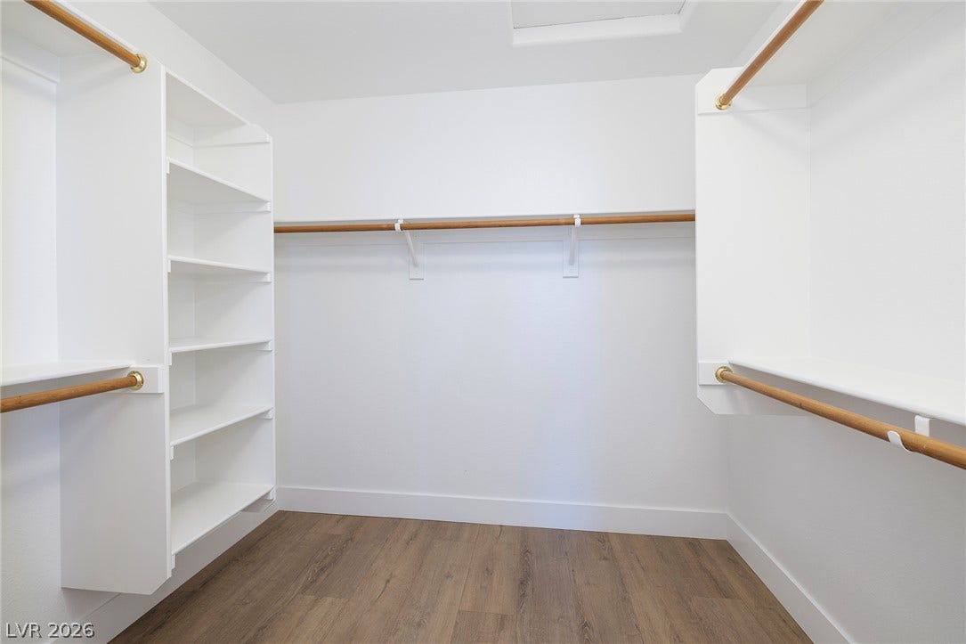 Walk-in Closet featuring built-in shelving and two-tier hanging rods.