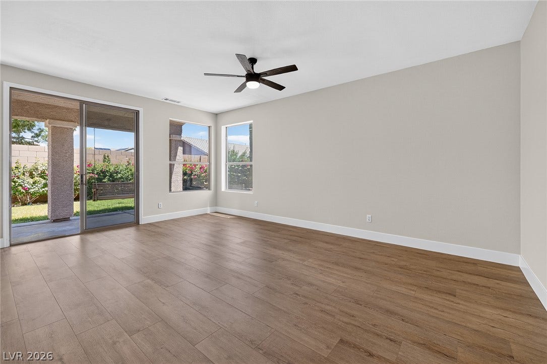 A versatile living space with robust LVP flooring and natural light, overlooking the expansive covered patio.