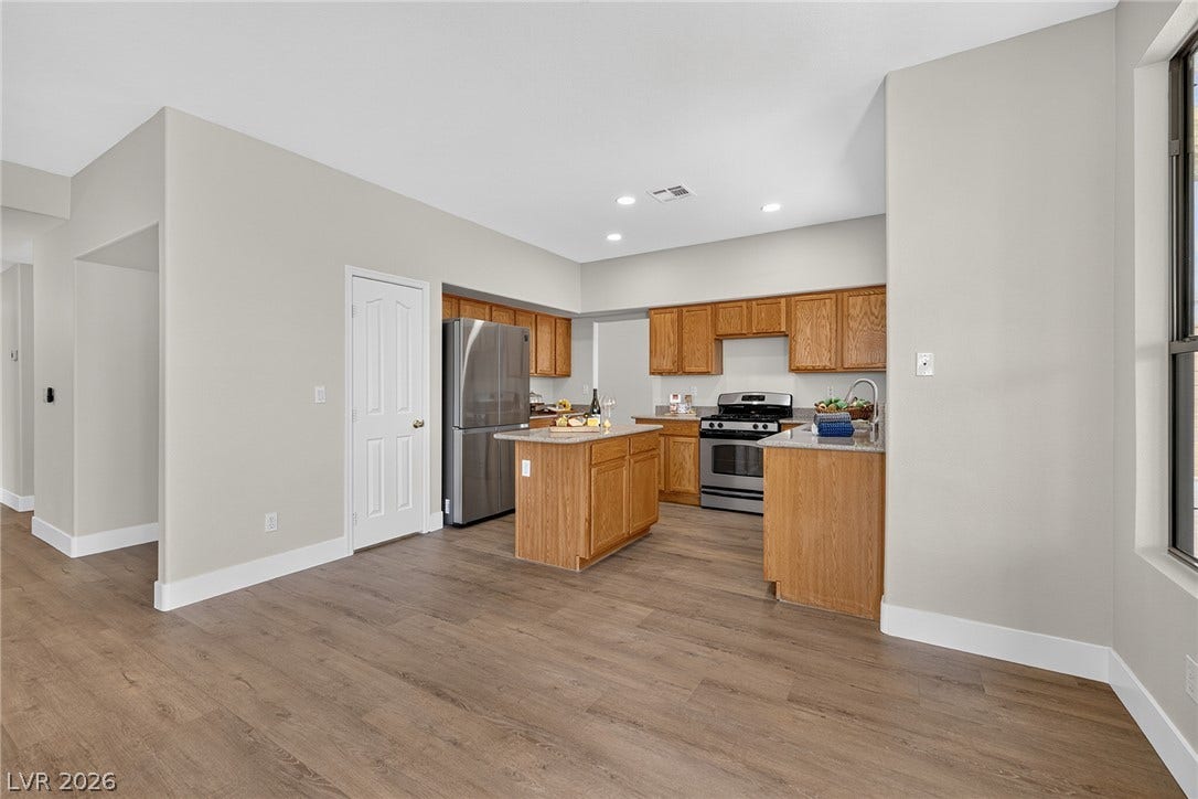 An inviting open-concept kitchen features a functional island, Silestone counters and stainless steel appliances.