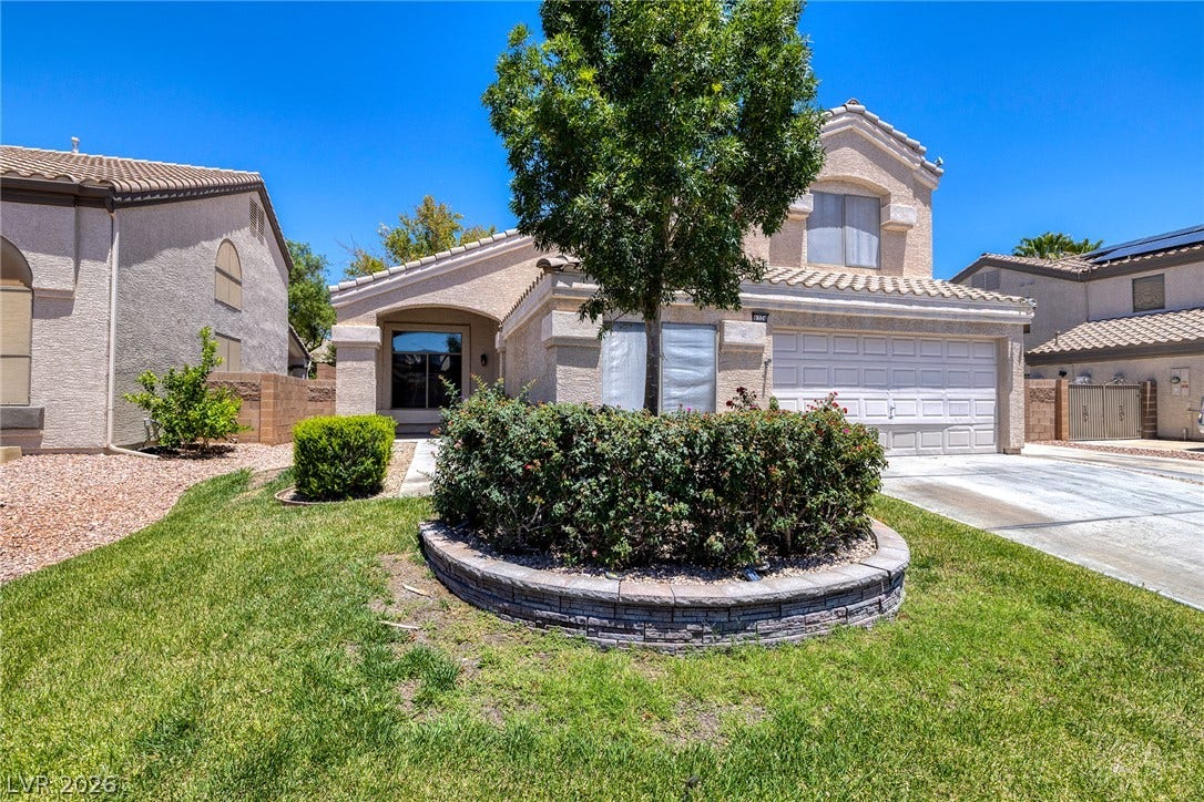 Mature landscaping provides inviting curb appeal to this two-story residence.