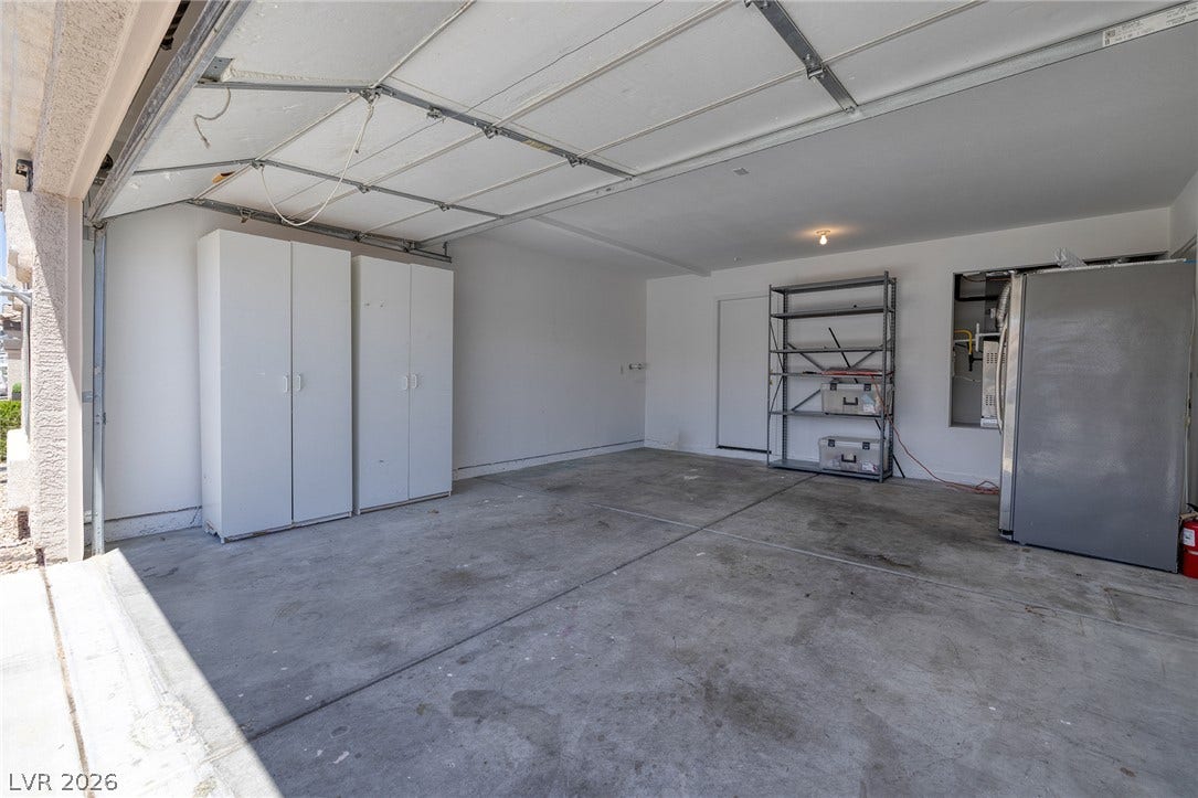 Two-car garage with cabinets, bonus refrigerator and service door to side yard for easy RV access.