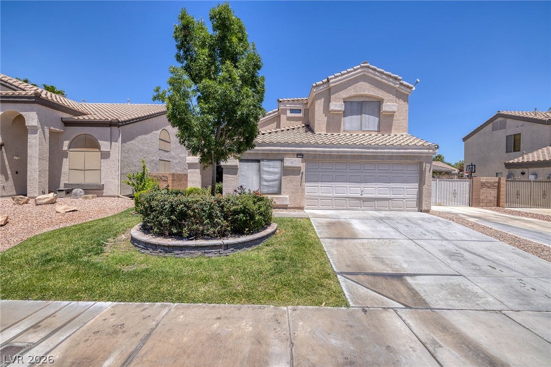 Well-maintained front landscaping with a mature tree and established shrubbery offers charming curb appeal.
