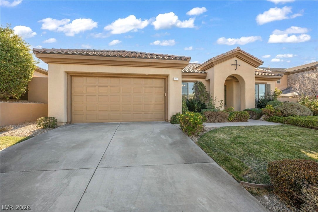 37 Stonemark Drive, Henderson, NV 89052 Mediterranean / spanish-style home featuring a tiled roof, an attached garage, stucco siding, and concrete driveway