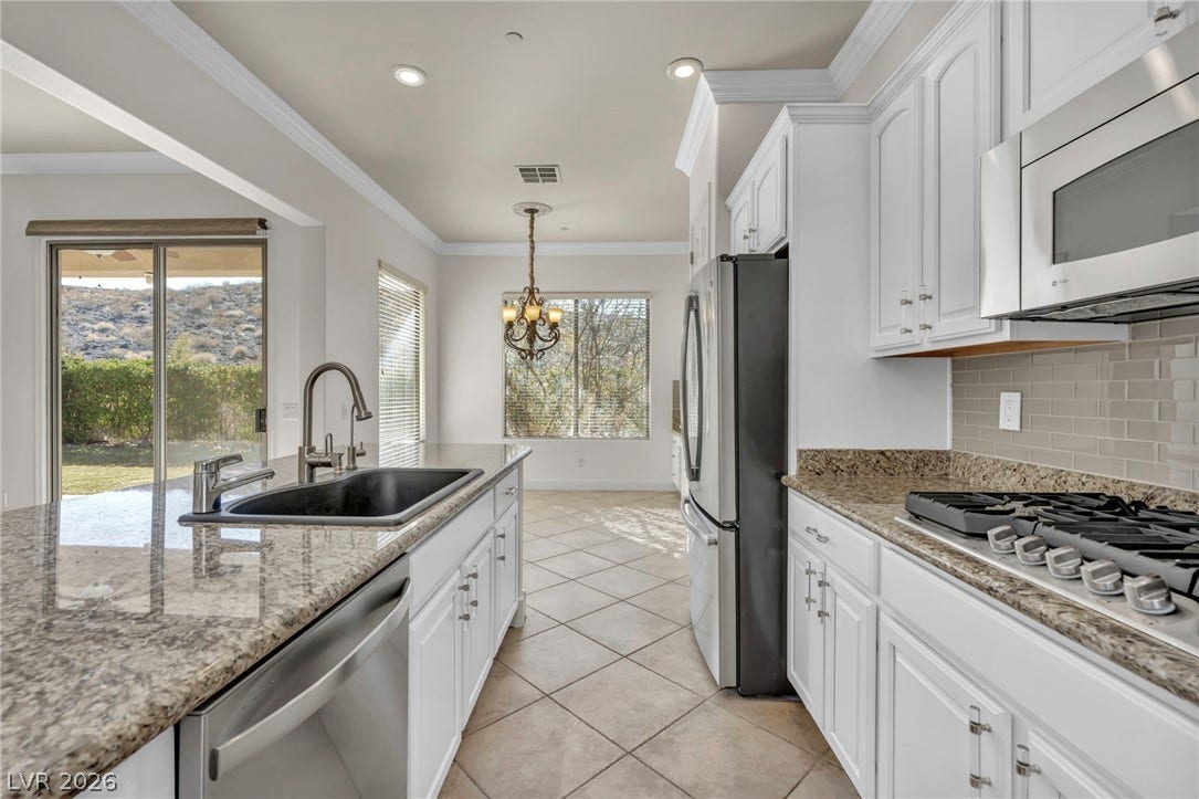 37 Stonemark Drive, Henderson, NV 89052 Kitchen featuring tasteful backsplash, a notable chandelier, a sink, white cabinetry, and stainless steel appliances