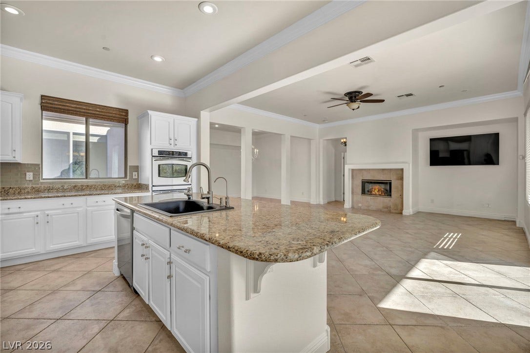 37 Stonemark Drive, Henderson, NV 89052 Kitchen featuring appliances with stainless steel finishes, light tile patterned floors, a center island with sink, ceiling fan, and a sink