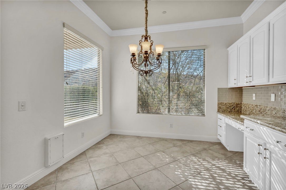37 Stonemark Drive, Henderson, NV 89052 Unfurnished dining area with light tile patterned floors, a notable chandelier, baseboards, and crown molding