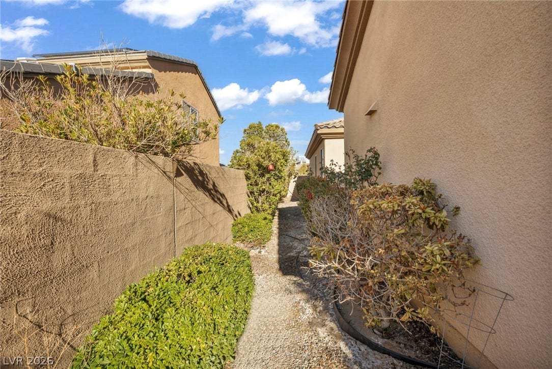 37 Stonemark Drive, Henderson, NV 89052 View of side of property featuring stucco siding, a tiled roof, and fence