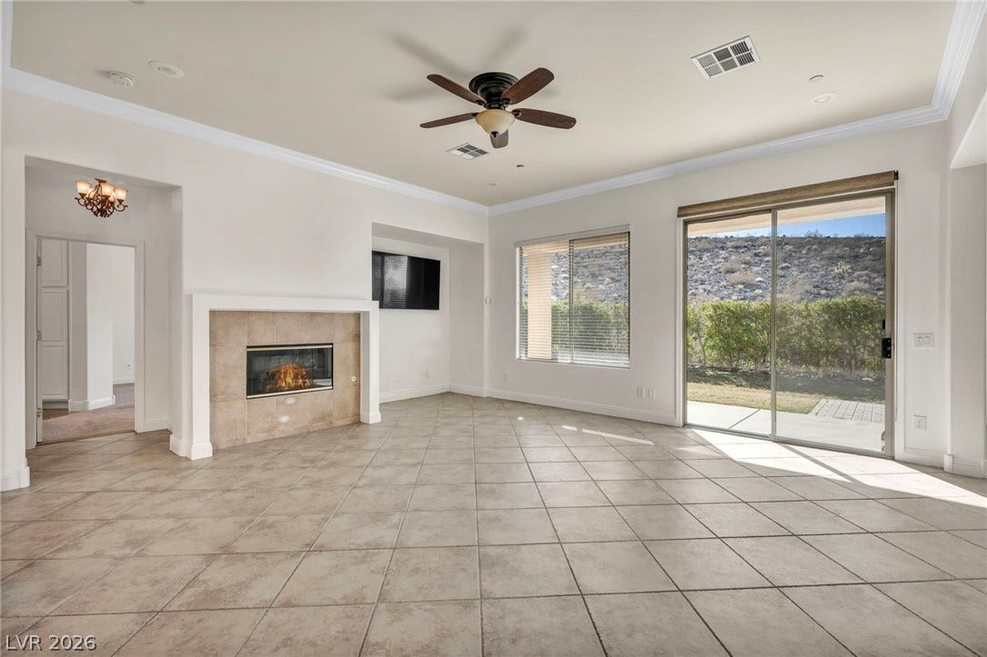 37 Stonemark Drive, Henderson, NV 89052 Unfurnished living room with visible vents, baseboards, light tile patterned floors, a ceiling fan, and crown molding