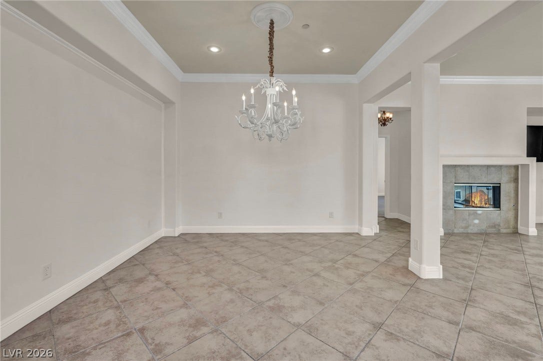 37 Stonemark Drive, Henderson, NV 89052 Unfurnished dining area featuring ornamental molding, a chandelier, recessed lighting, tile patterned flooring, and a tile fireplace