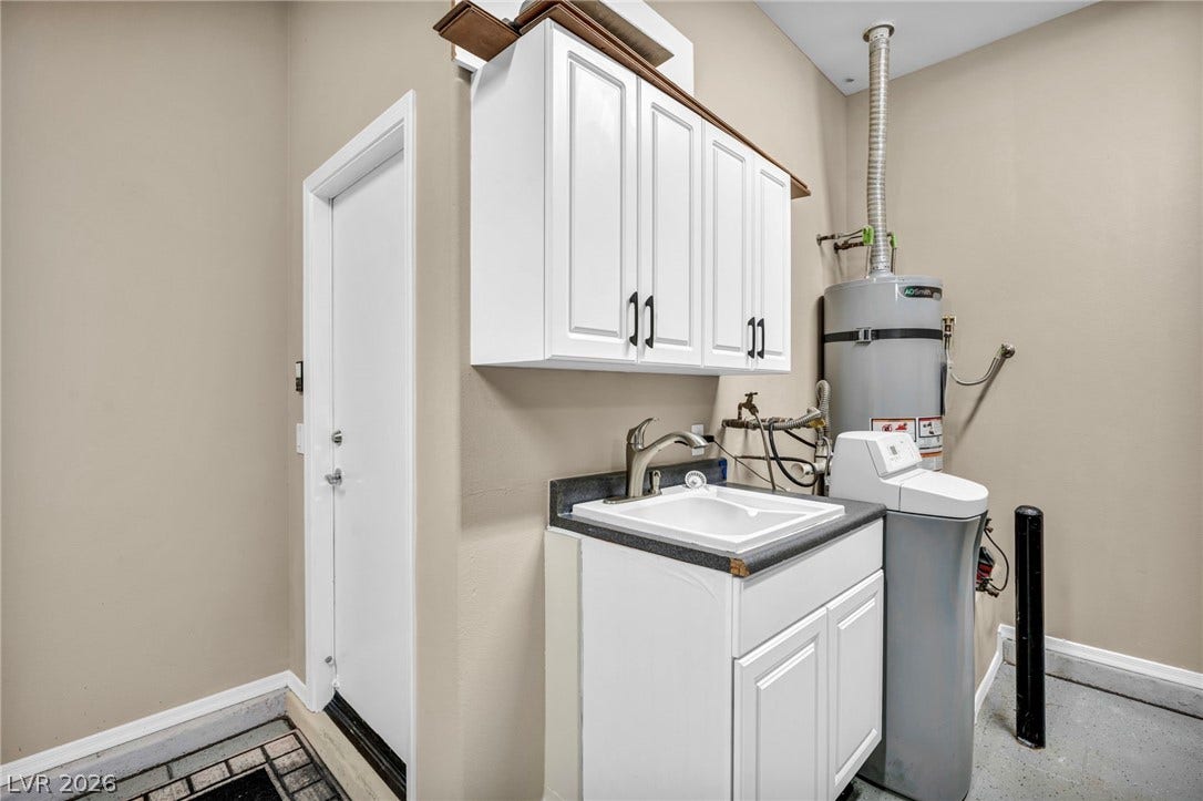 37 Stonemark Drive, Henderson, NV 89052 Clothes washing area with a sink, secured water heater, baseboards, and cabinet space