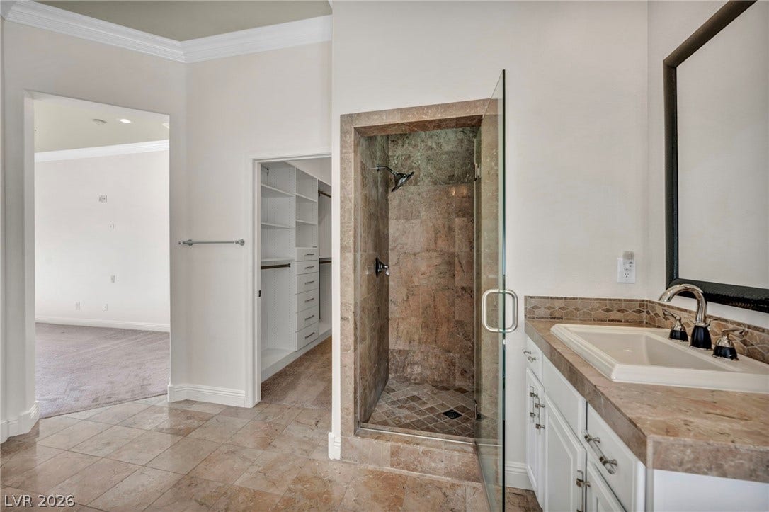 37 Stonemark Drive, Henderson, NV 89052 Bathroom featuring a walk in closet, crown molding, vanity, and a stall shower