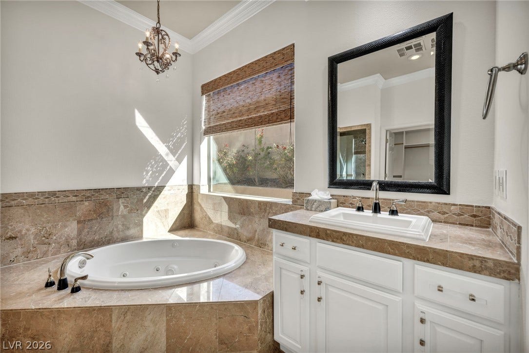 37 Stonemark Drive, Henderson, NV 89052 Bathroom featuring visible vents, an inviting chandelier, ornamental molding, a jetted tub, and vanity
