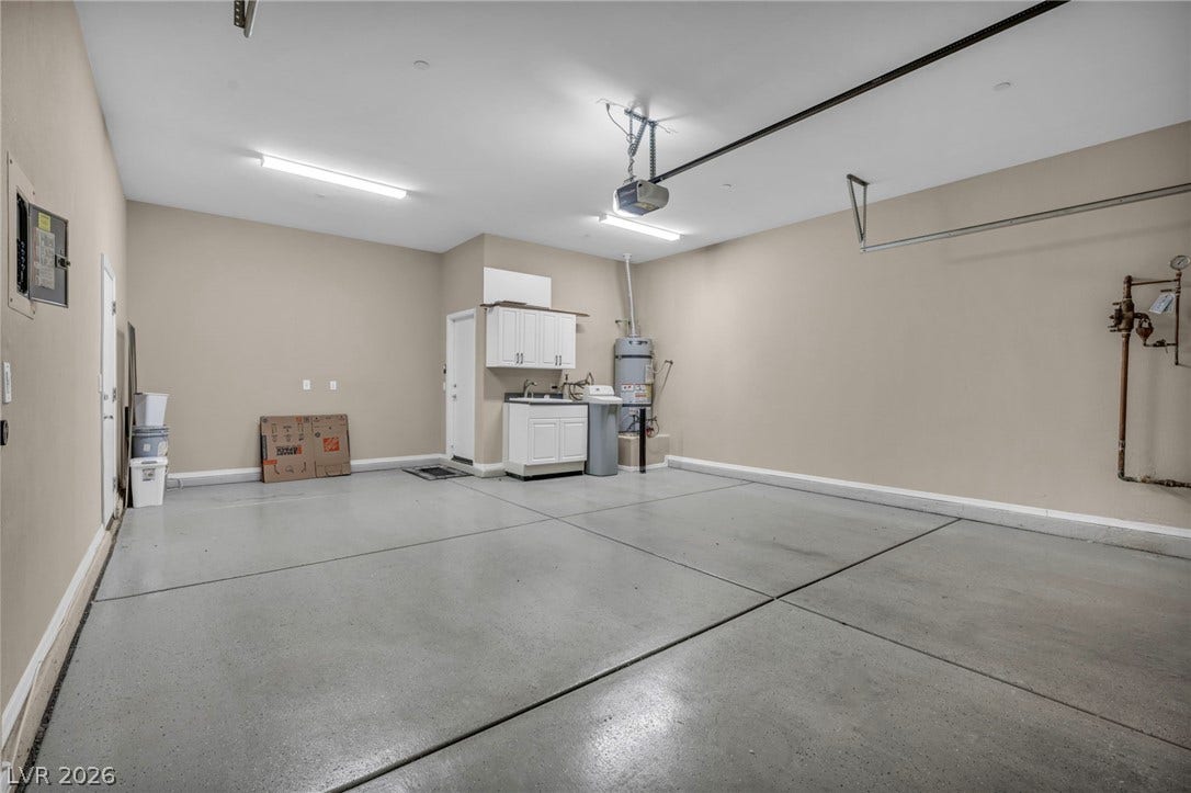 37 Stonemark Drive, Henderson, NV 89052 Garage with a garage door opener, a sink, baseboards, and water heater