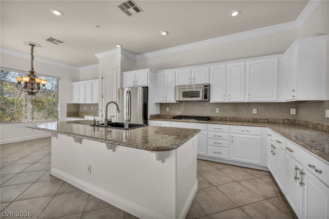 37 Stonemark Drive, Henderson, NV 89052 Kitchen featuring light tile patterned floors, stone counters, white cabinetry, appliances with stainless steel finishes, and a sink