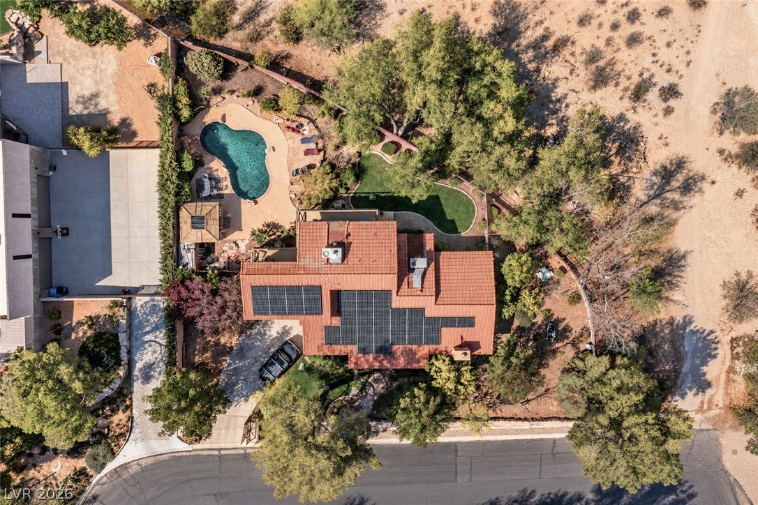 29 Cottonwood Drive, Blue Diamond, NV 89004 An aerial perspective reveals the private pool, solar-paneled roof, and mature surrounding landscape.