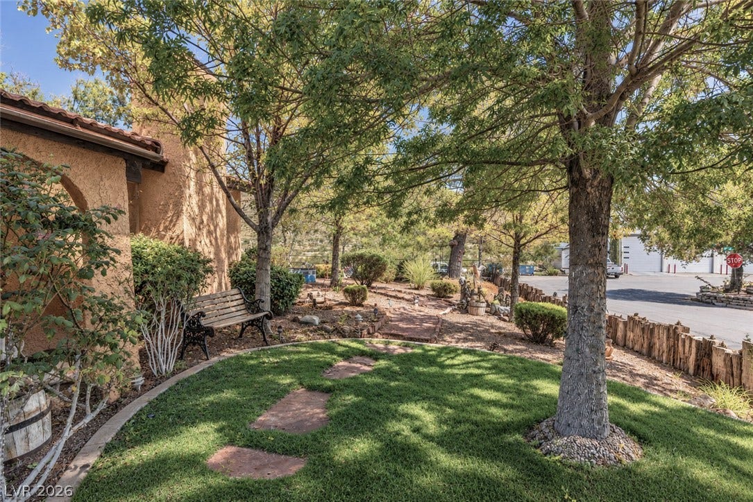 29 Cottonwood Drive, Blue Diamond, NV 89004 Mature trees shade a curved stone pathway winding through the landscaped front yard.