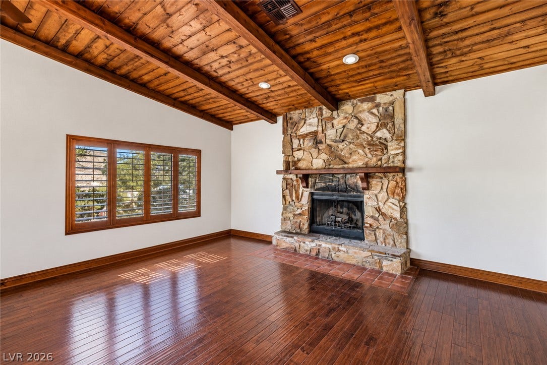 29 Cottonwood Drive, Blue Diamond, NV 89004 Rich wood plank ceilings and a towering stone fireplace define this inviting living space.