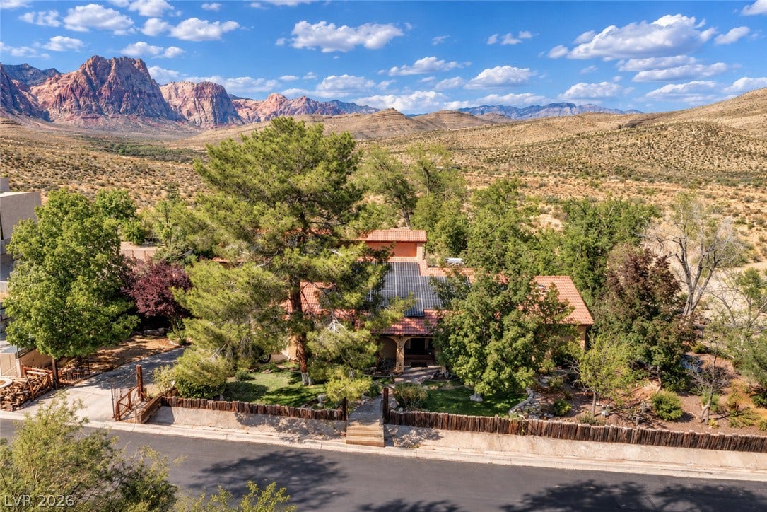 29 Cottonwood Drive, Blue Diamond, NV 89004 Dramatic desert peaks form a spectacular backdrop for this tile-roofed residence nestled among mature trees.