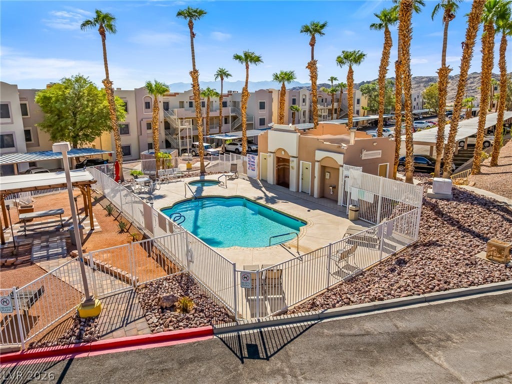 2036 Mesquite Lane, #303, Laughlin, NV 89029 Fenced community swimming pool and spa are surrounded by towering palm trees.