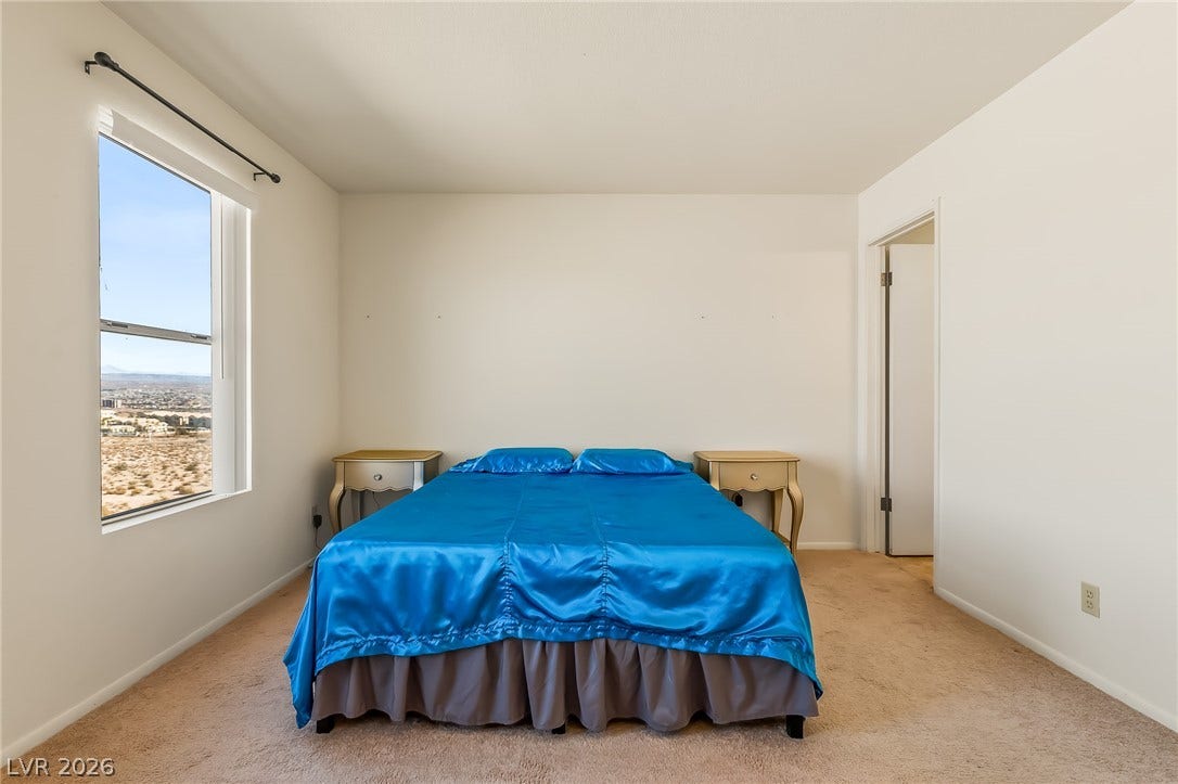 2036 Mesquite Lane, #303, Laughlin, NV 89029 Plush carpeting and a large window framing desert views define this peaceful bedroom.