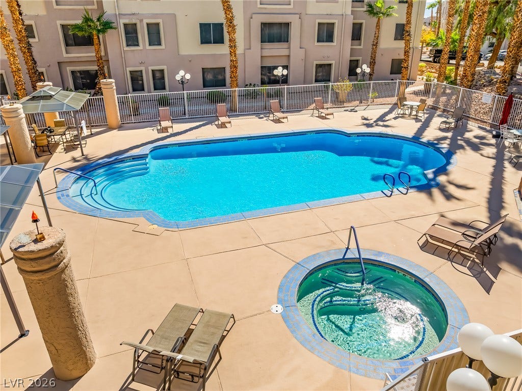 2036 Mesquite Lane, #303, Laughlin, NV 89029 An inviting swimming pool and circular spa sit surrounded by a concrete patio.