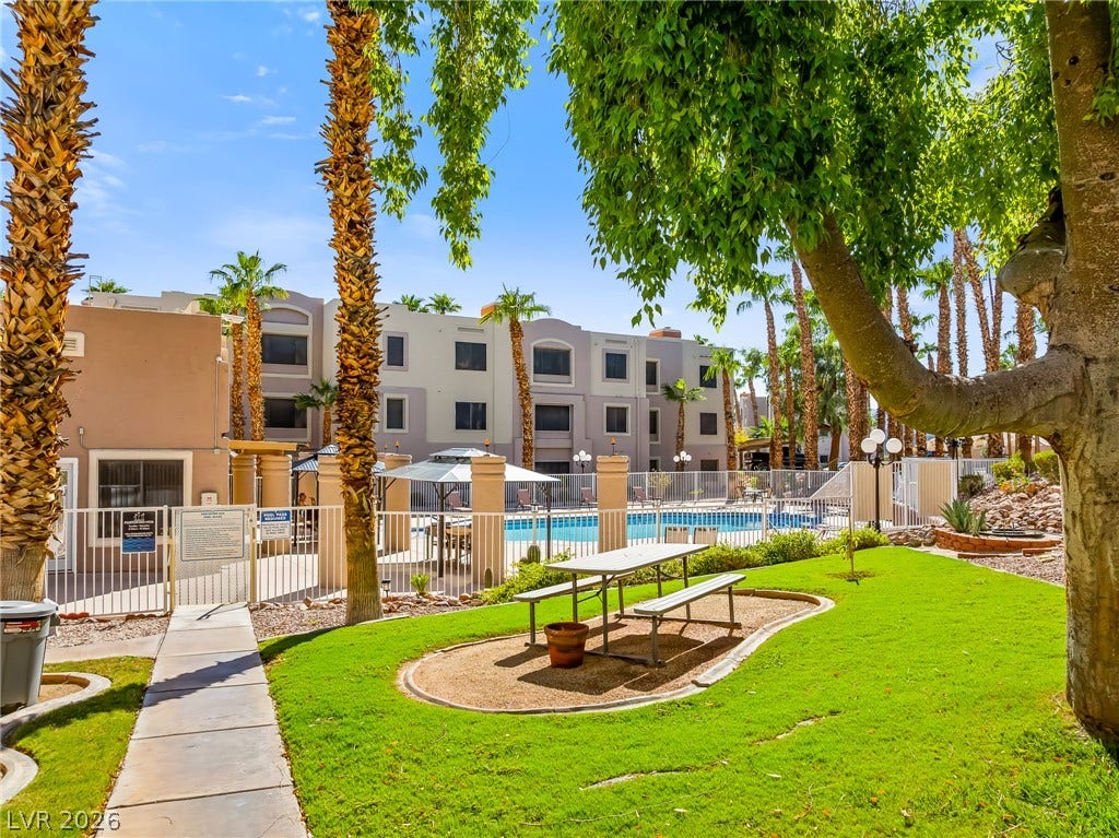 2036 Mesquite Lane, #303, Laughlin, NV 89029 Lush green lawns and mature trees frame the community pool area on a bright day.