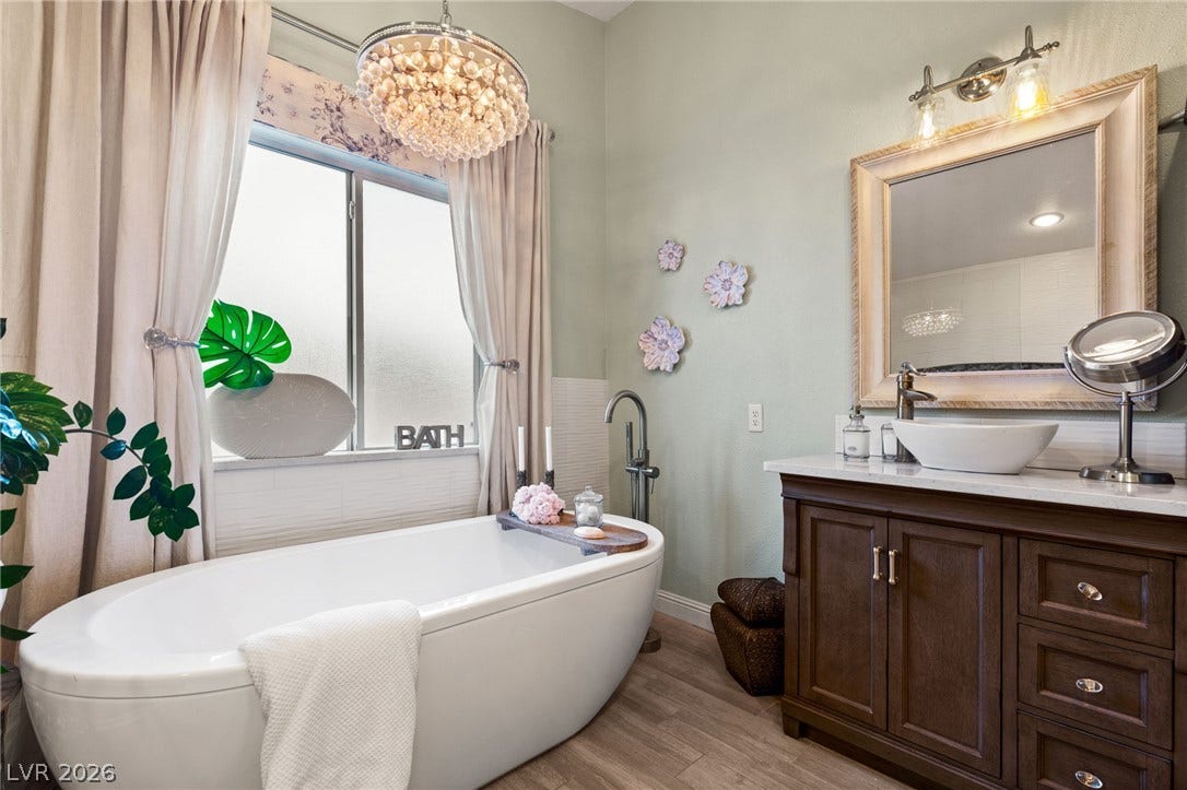 3950 Candleglow Court, Las Vegas, NV 89147 Elegant bathroom spaces highlighted by a freestanding soaking tub and dark wood vanity cabinetry.