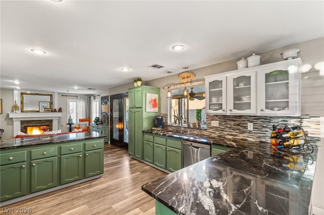 3950 Candleglow Court, Las Vegas, NV 89147 Richly patterned stone countertops anchor this open kitchen and adjacent hearthside living space.